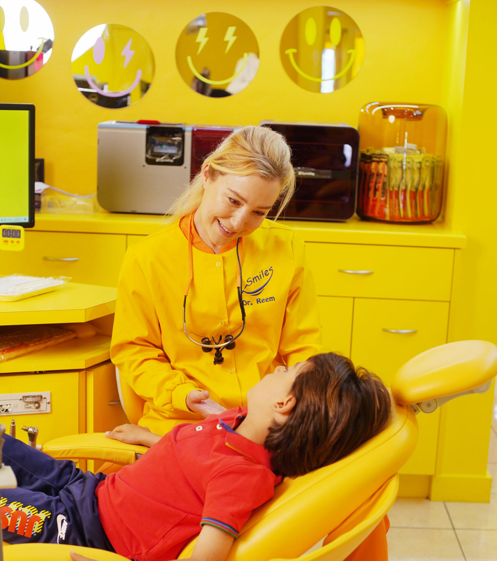 Pediatric Dentist Dr. Reem Consulting with Young Soccer Player Before Custom Mouthguard Fitting