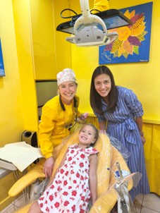 Pediatric Dentist Dr. Reem with Child and Parent in Dental Office